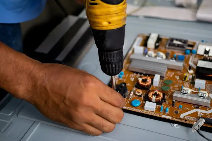Técnico realizando reparo em placa eletrônica de TV